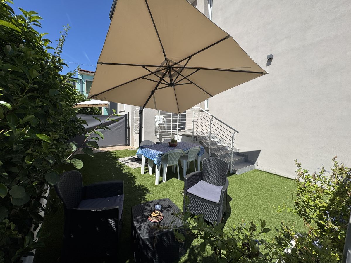 Il giardino visto dall'ingresso, con il prato e la siepe che lo delimita